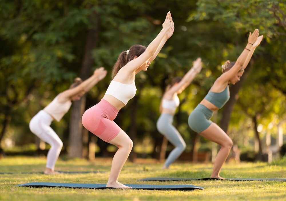 A Group of Women Practising Utkatasana Chair Pose
