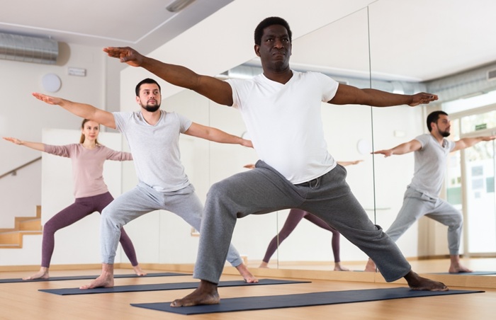A Group of Students Practicing Warrior Pose 2