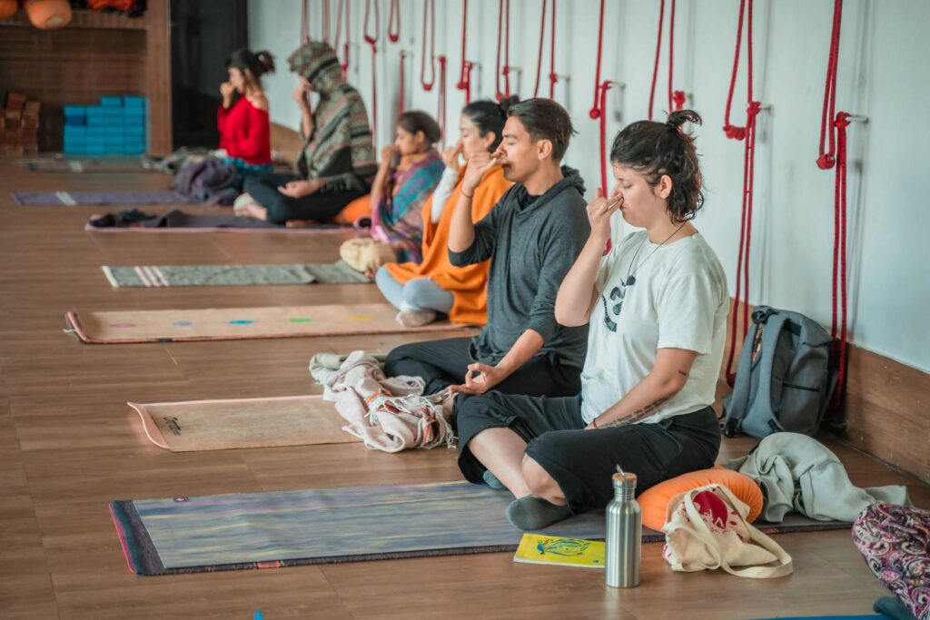 Yoga students practicing alternate nostril breathing